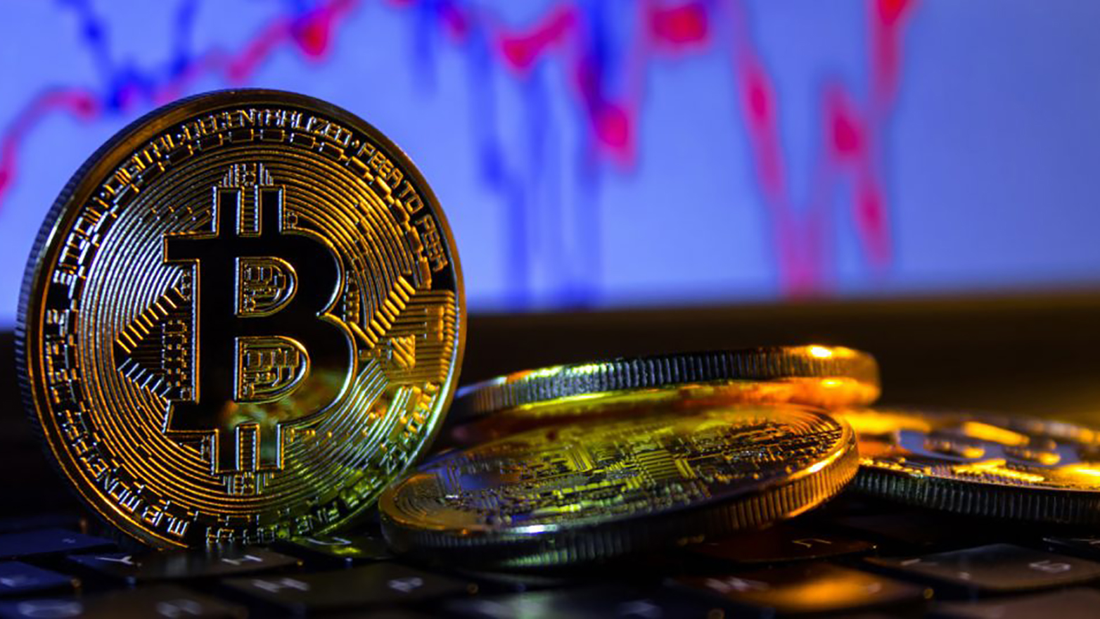 bitcoins on a table with statistical graphics in the background